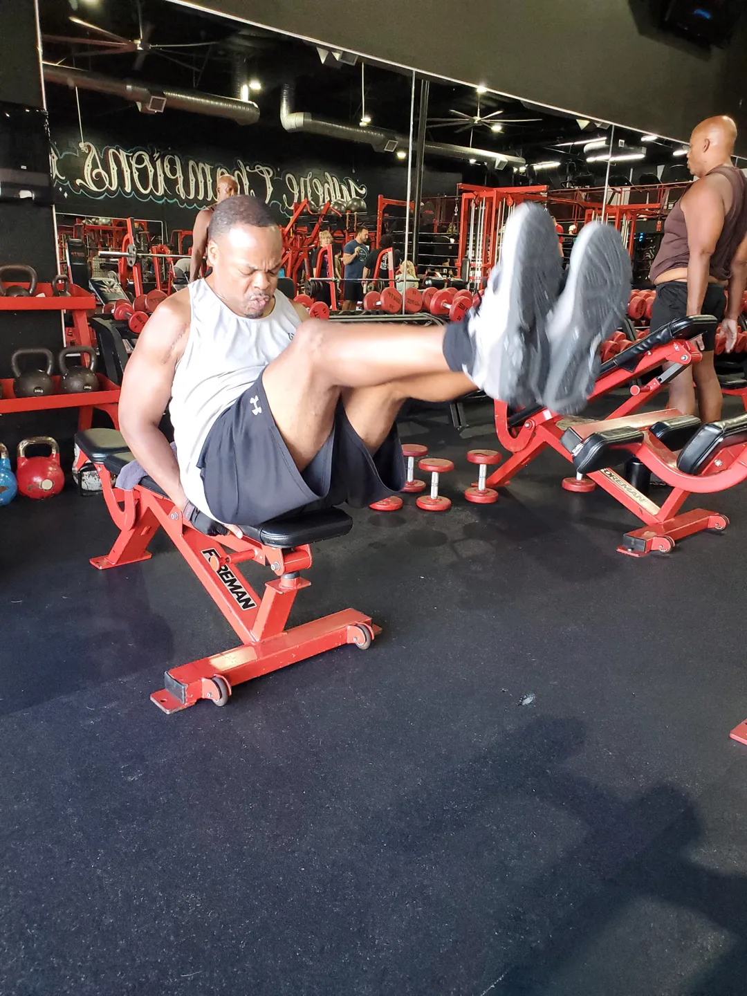 A BizzFit client doing bench knee tucks — part of The Standard finisher