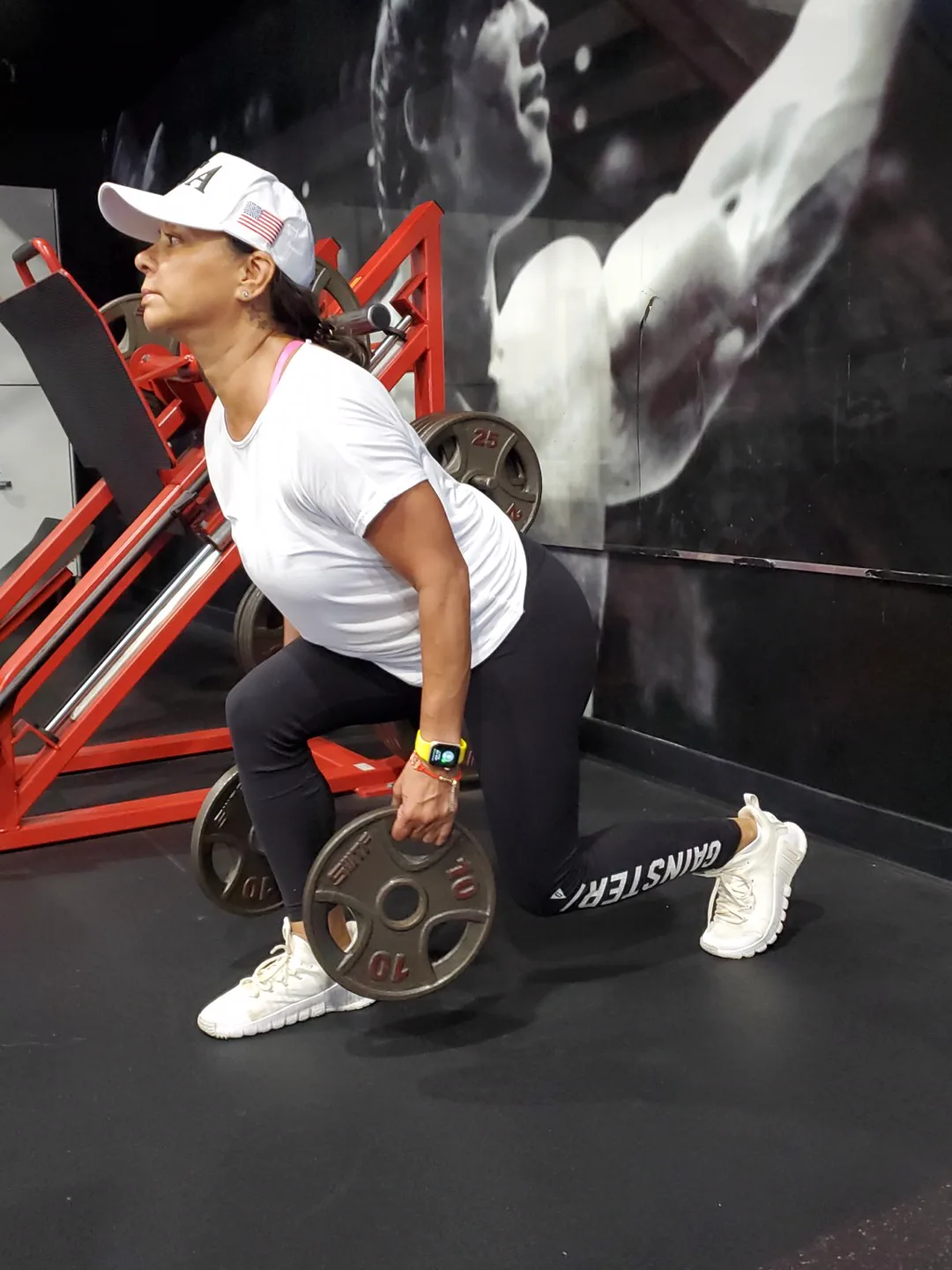 A BizzFit client lunging with plates during strength training