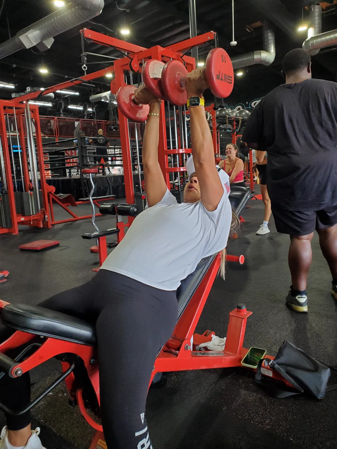 A BizzFit client pressing dumbbells on the incline bench
