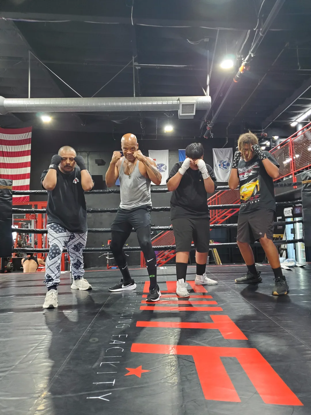 Coach Bizz and his fighters with their guards up in the ring